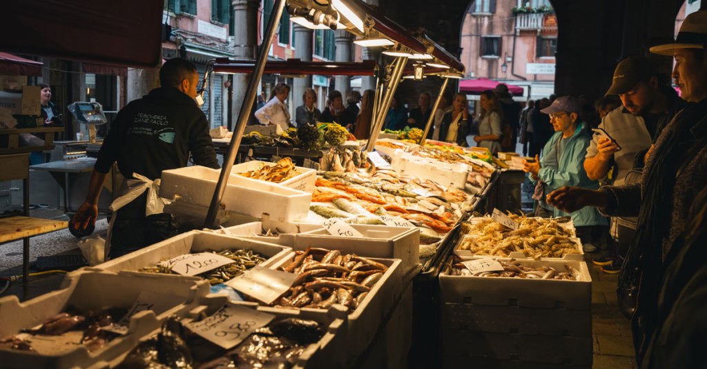 People look at fish at a fish market in Venice, Italy.